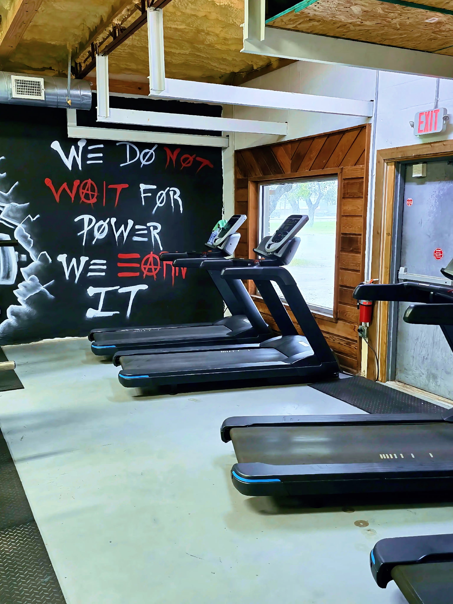 Treadmills with We Earn It wall